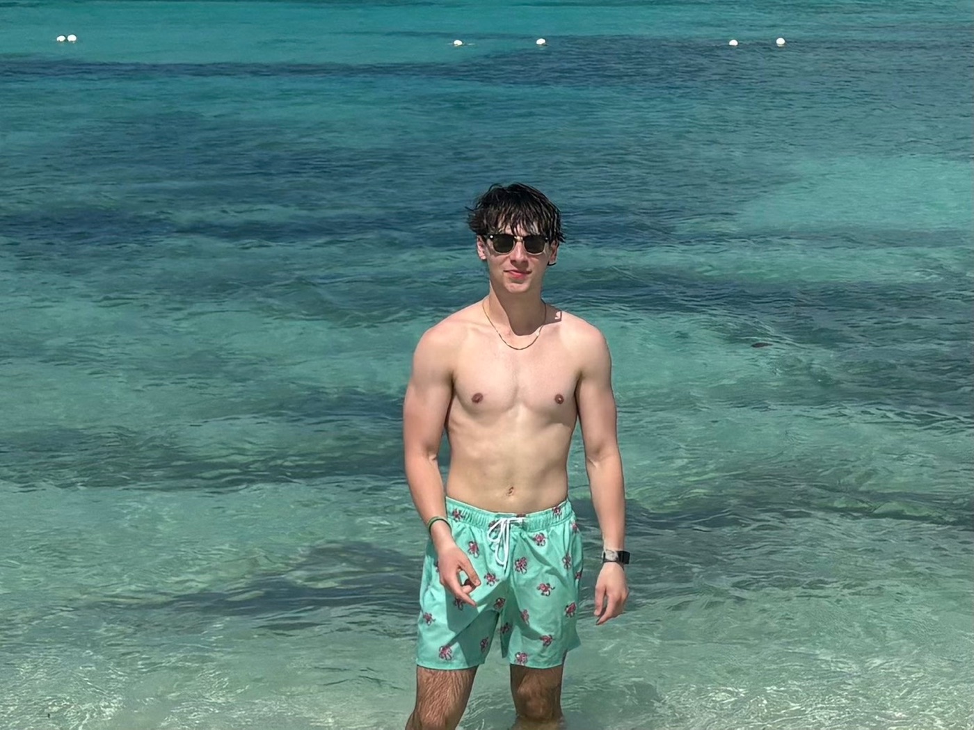 Colin standing in clear turquoise water at the beach